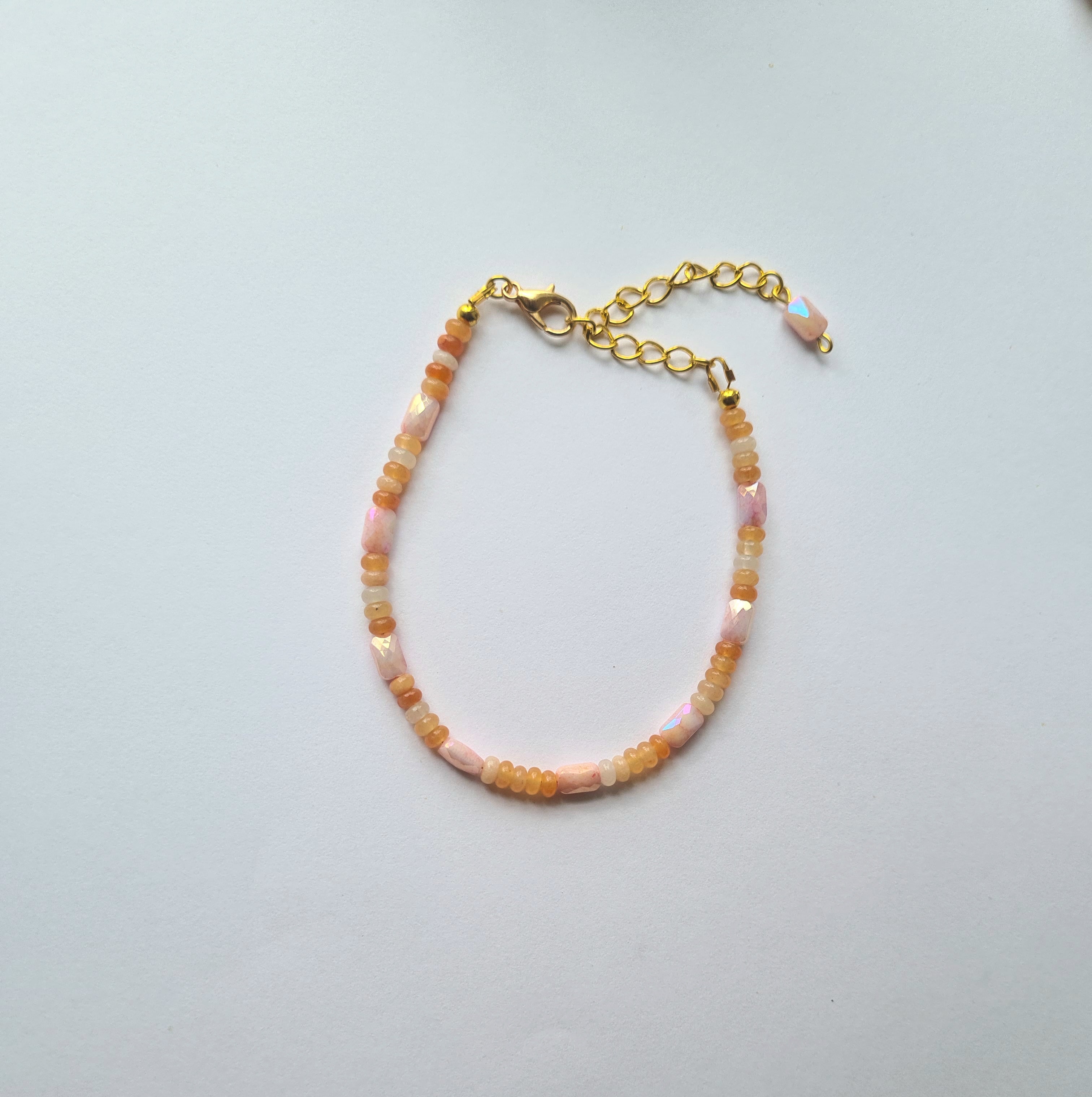Full view of orange opal bracelet with gold lobster clasp and extension chain